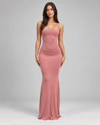 Femme portant une robe Anaïs rose pastel longue et moulante à fines bretelles, vue de face ,douce, féminine et glamour