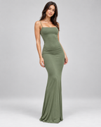 Femme portant la robe Anaïs vert, vue de face en silhouette entière, avec coupe longue moulante à fines bretelles, pour une allure élégante, féminine et naturelle.