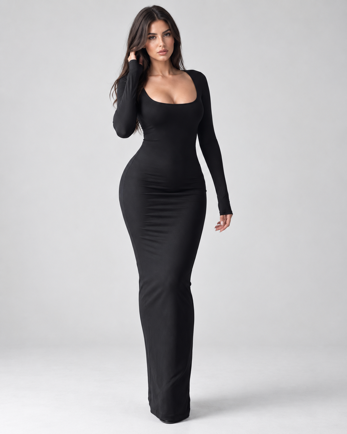 Femme portant une robe Laura noire longue et moulante à col carré et manches longues, vue de face en pied, glamour, sensuelle et élégante.
