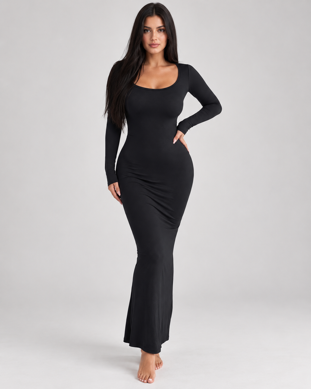 Femme portant une robe Laura noire longue et moulante à manches longues et col carré, vue de face en pied, élégante, féminine et naturelle.