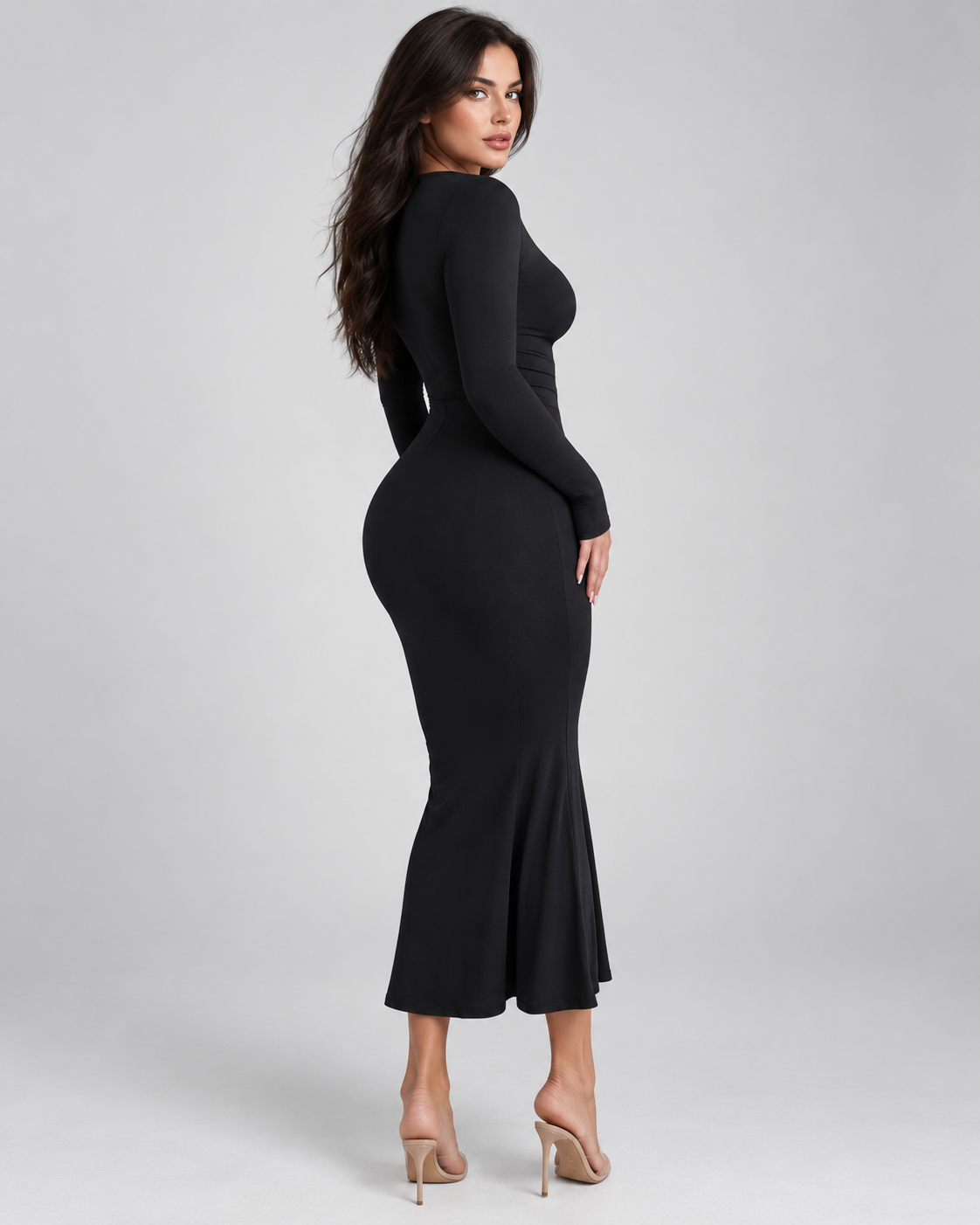 Femme portant une robe Laura noire longue et moulante à manches longues, vue trois-quarts dos, silhouette élégante, féminine et raffinée.