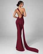 Femme portant la Robe Lina bordeaux vue de dos, avec dos nu plongeant, détail froncé et longue traîne pour une allure sophistiquée