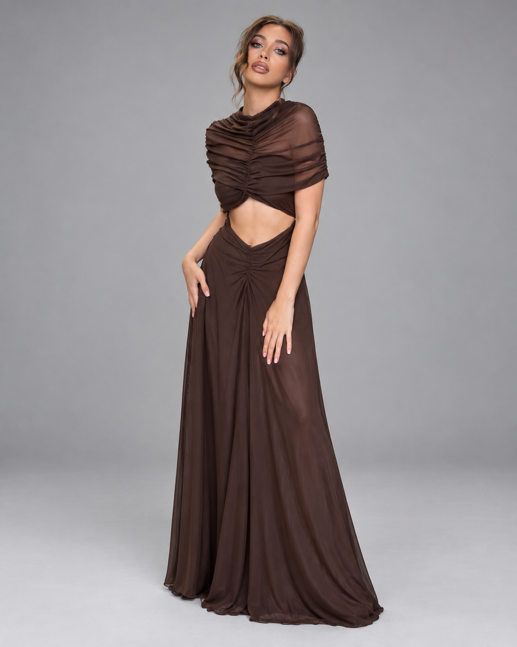 Femme portant une robe Manon marron longue et moulante froncée à découpe taille, vue trois-quarts en pied, naturelle, élégante et sophistiquée