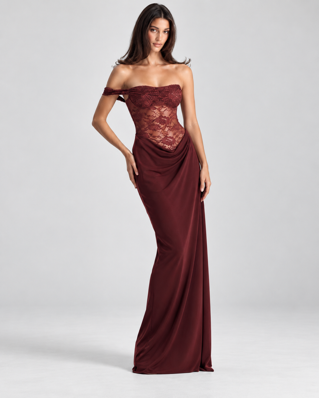 Femme portant la Robe Maya bordeaux, vue de face, avec dentelle ajourée, épaules dénudées et longue coupe moulante, créant une silhouette élégante, romantique et sensuelle