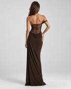 Femme portant la Robe Maya marron vue de dos, dévoilant le corsage en dentelle semi-transparente et le tombé long fluide de la robe pour une allure raffinée et séduisante