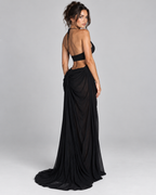 Femme portant la Robe Sofia noire vue de dos, mettant en valeur son dos largement dégagé et sa longue jupe fluide pour une allure audacieuse et raffinée