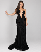 Femme portant la Robe Sofia noire, vue de face, avec décolleté découpé, détails ajourés et longue jupe drapée fluide pour une silhouette élégante et sensuelle